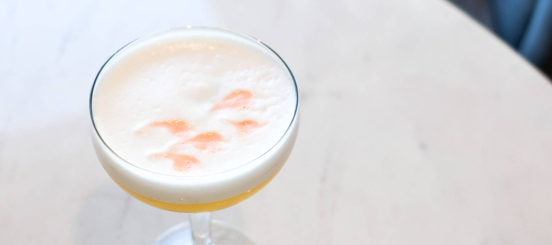 Pisco Sour Floral Cocktail with fresh lemon juice, bitters, and cherry blossom green tea mixology