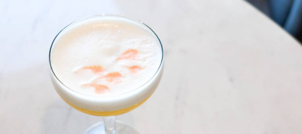 Pisco Sour Floral Cocktail with fresh lemon juice, bitters, and cherry blossom green tea mixology 